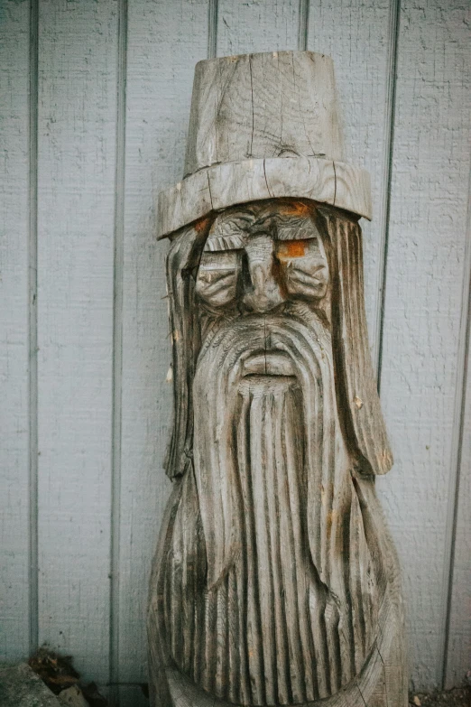 a carved wood head with an old style hat on