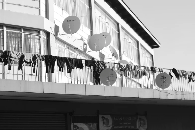 a black and white po with many pieces of paper hanging from the balcony