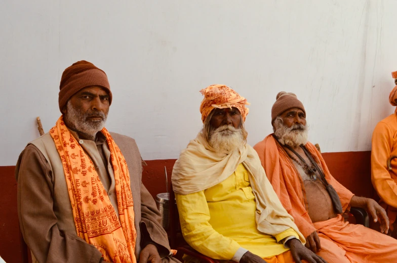 men sit on a bench wearing warm clothes