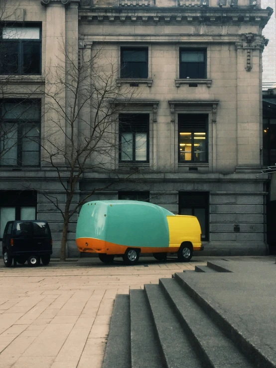 a blue and orange truck is parked outside a building