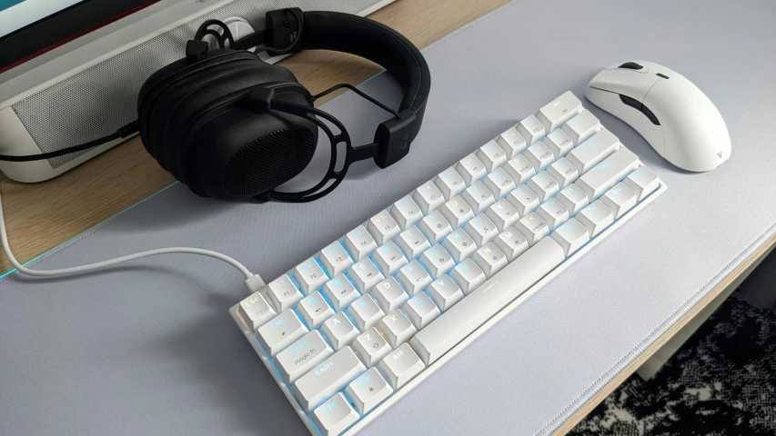 a keyboard with headphones on top, a mouse on the other side