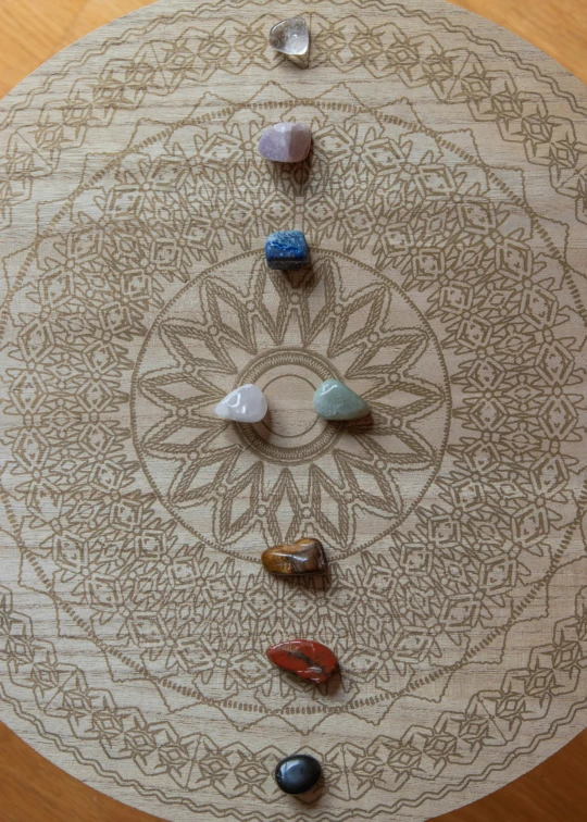 five stones of different colors arranged in a pattern on a white background