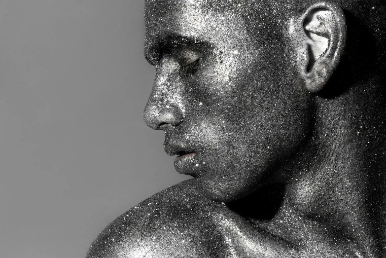 man covered with a metallic substance, face in profile