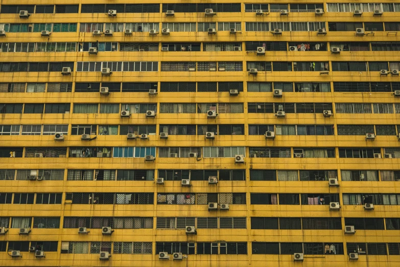 an apartment building in yellow with rows of windows