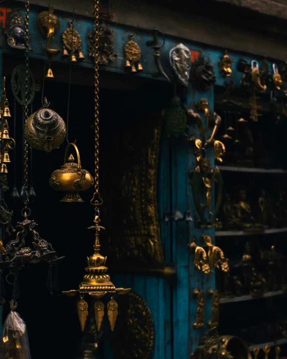 a wall full of golden bell ornaments with an open door