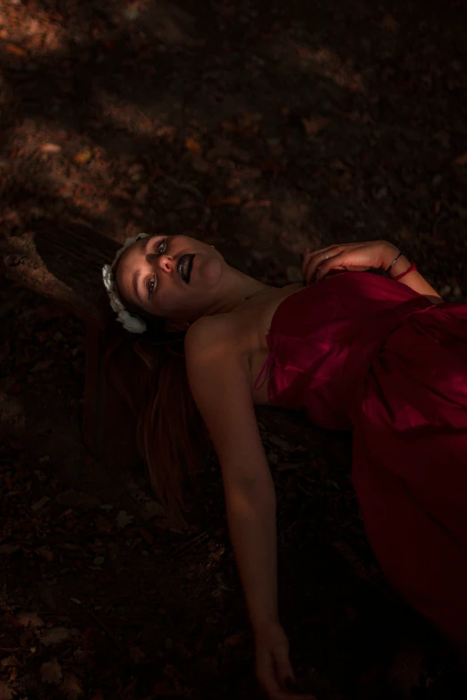 a girl wearing an evening dress lying on the ground