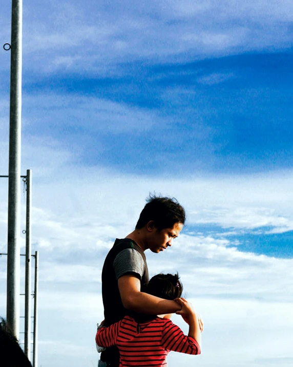 man carrying cat over his shoulders looking at camera