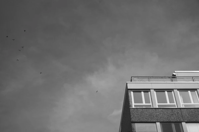 a grey building with windows, balconies and shutters