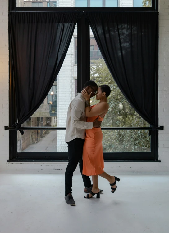 a man and woman dancing together in an art museum lobby