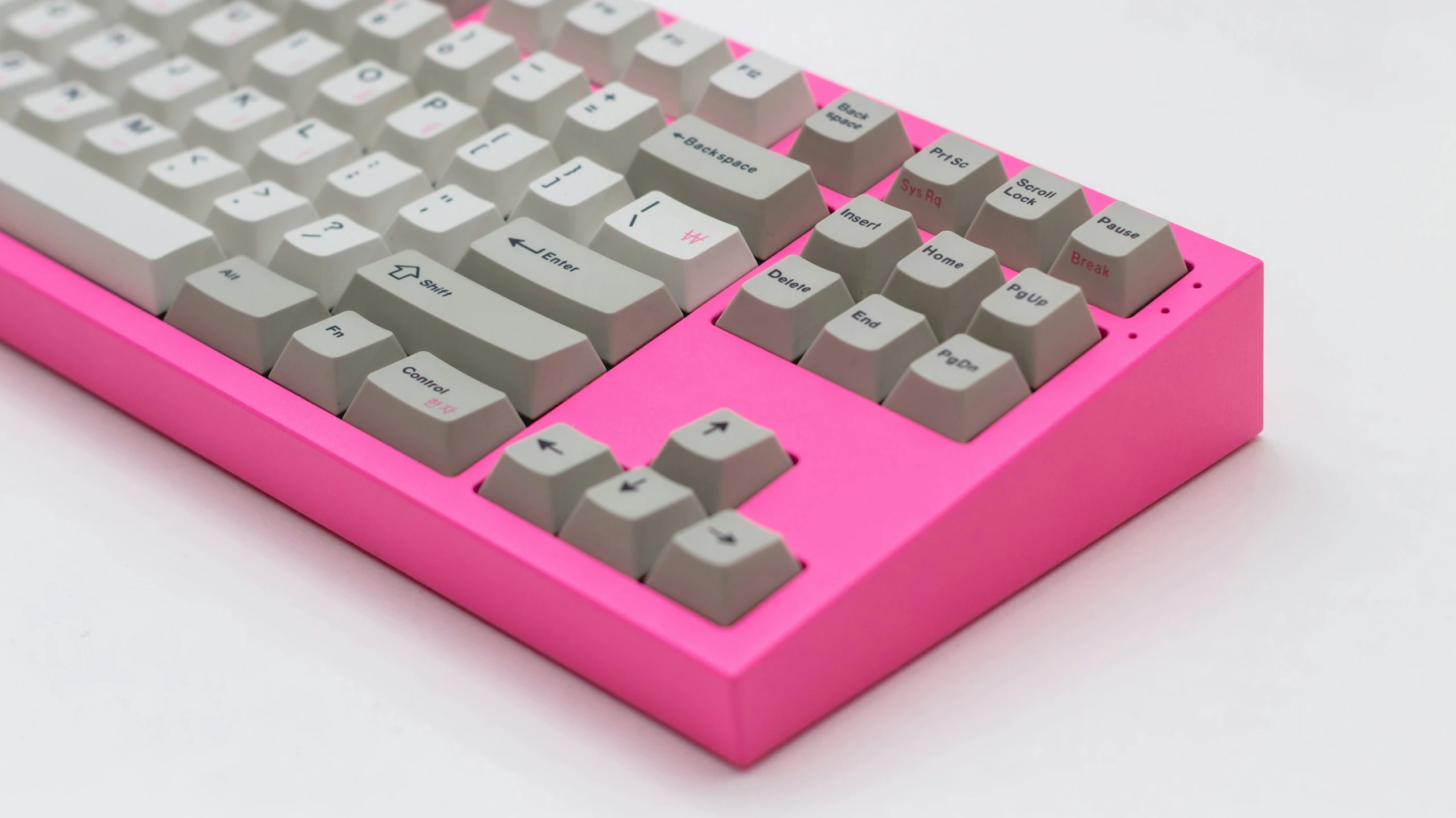 a pink and gray keyboard on a white table