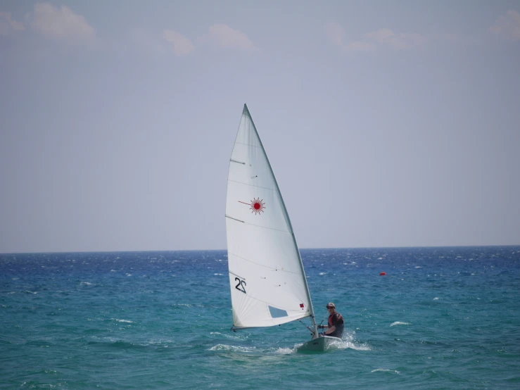 a person windsurfing in the ocean, on a very nice day