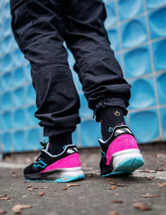 a person in black pants, a pink and blue shoe