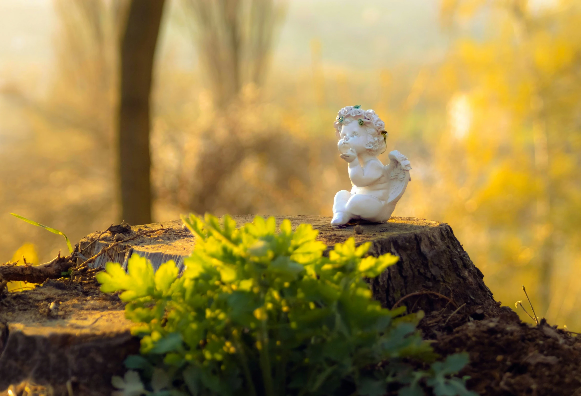 a statue of a boy is sitting on a tree stump