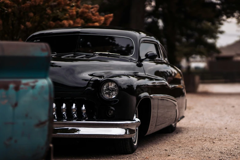 an old black car parked on the road