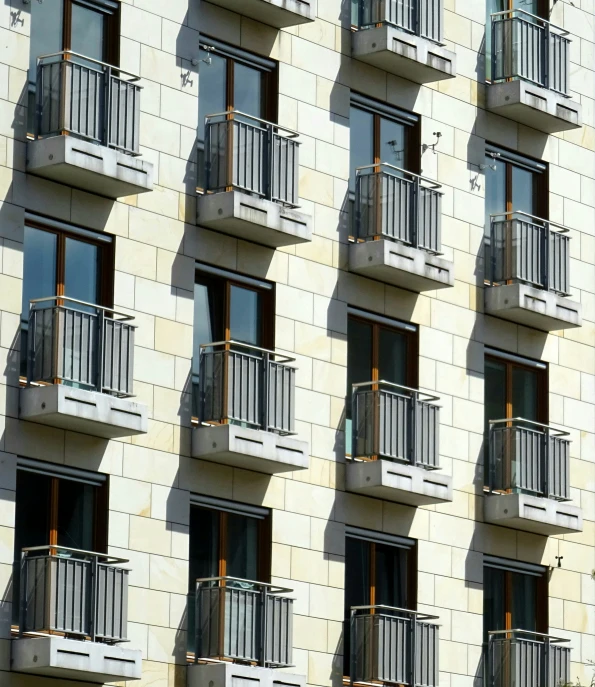 the shadow of a building on the street with many balconies