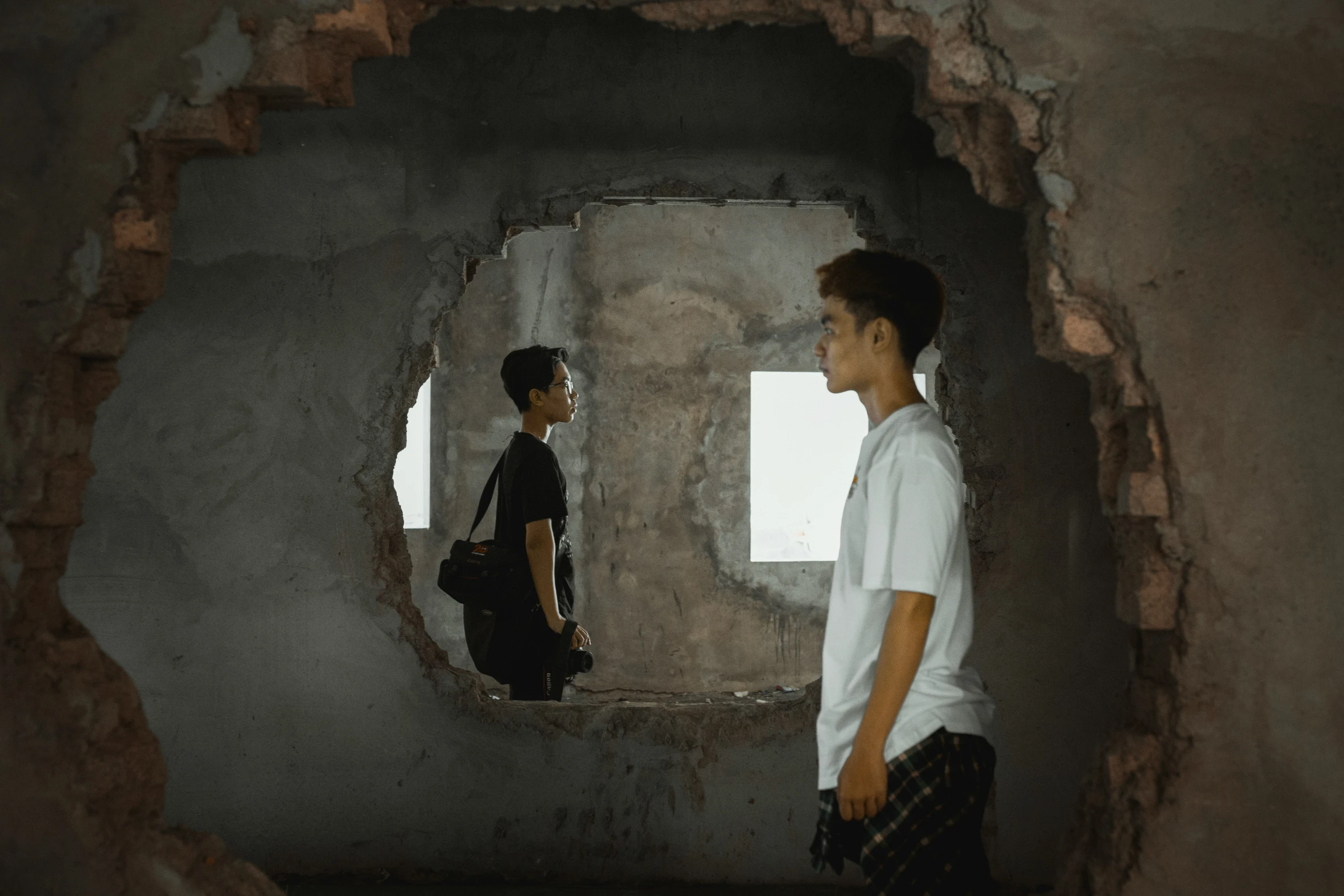 two young men are looking in an unusual cave