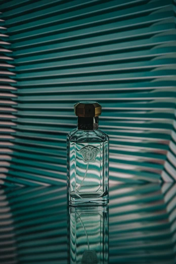 the bottle of cologne is next to a green striped wall