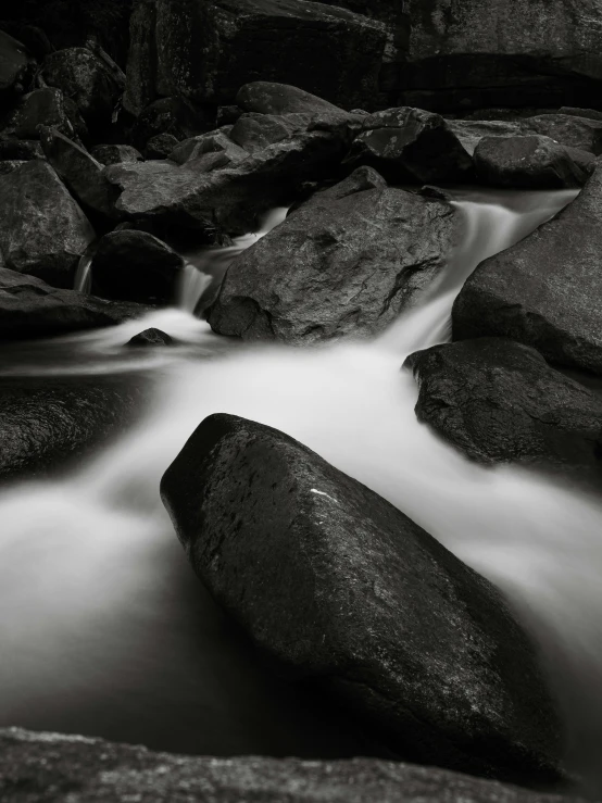 black and white pograph of rocks with stream