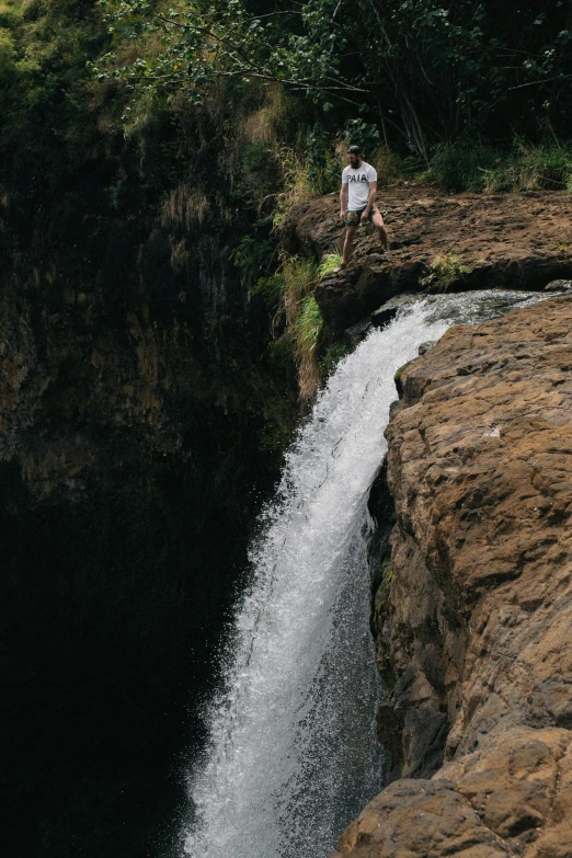 a man standing on the edge of a waterfall