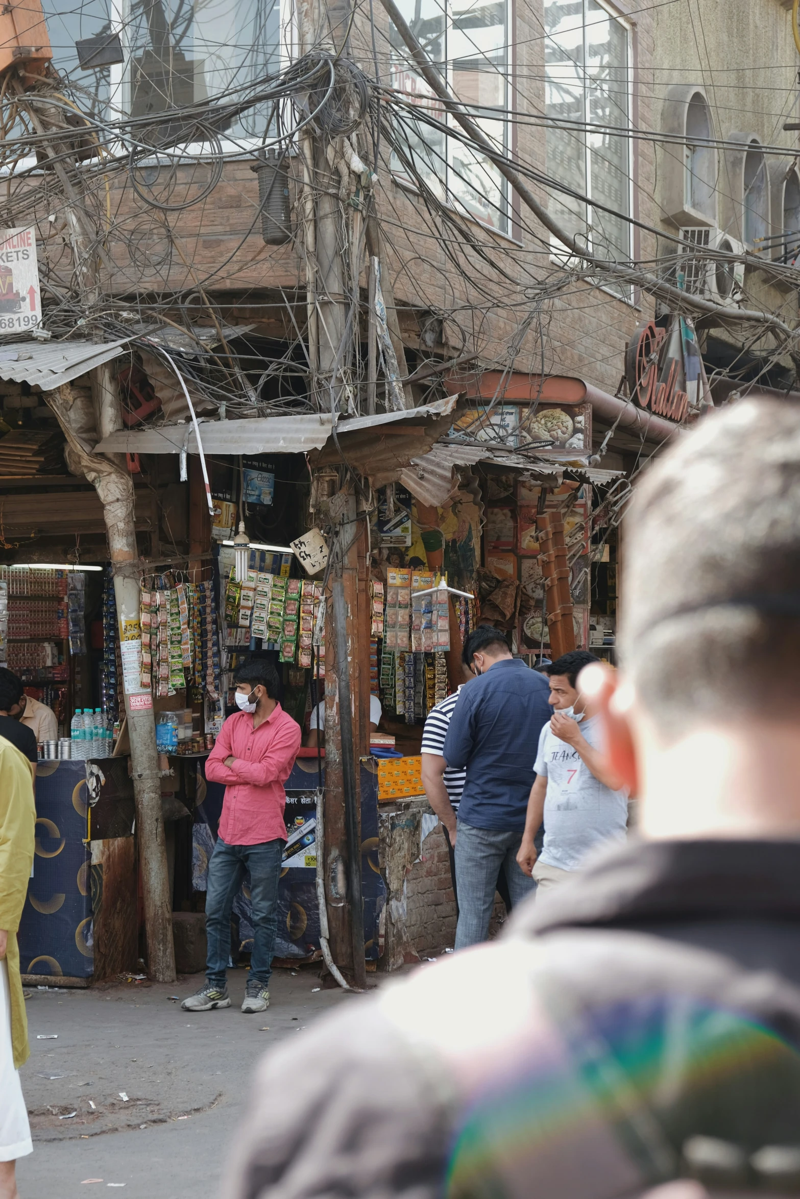 people standing in the corner of a market with multiple items