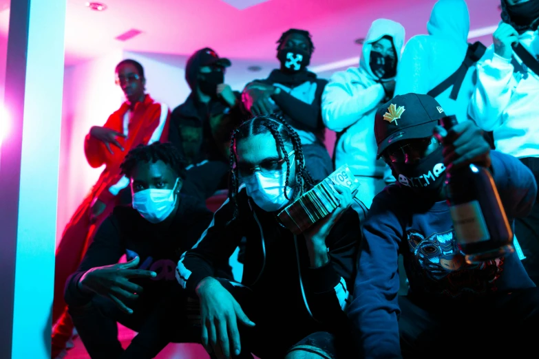 a group of masked people pose in front of a pink background