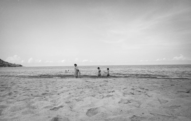 three young children playing in the sand on the beach