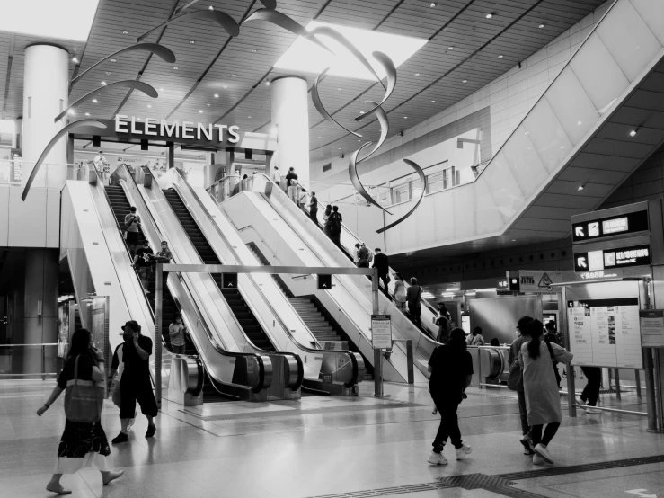 people with luggage and a large escalator in a train station