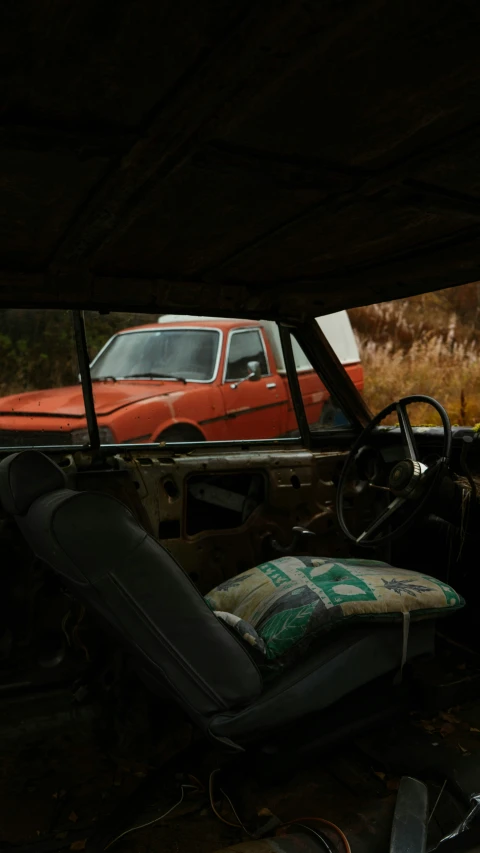 an old red pick up truck and chair inside of a garage