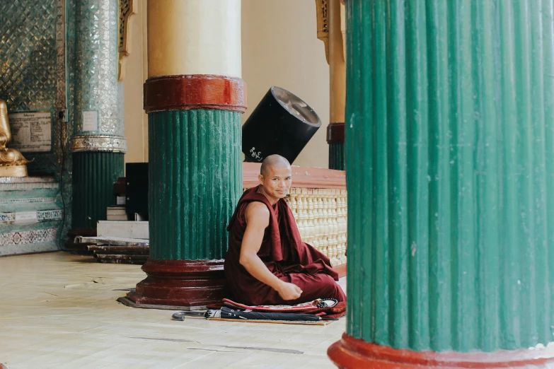 a monk sits in the middle of an ornate building