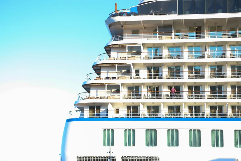 the large boat is white and blue with lots of windows