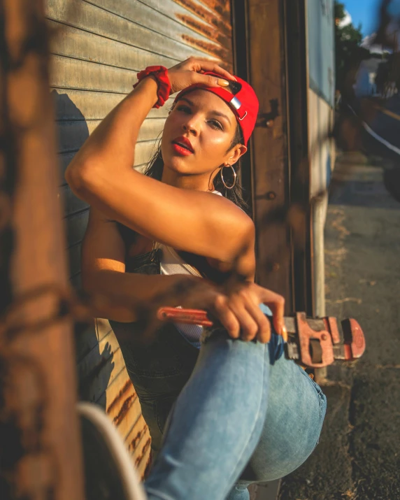 a woman wearing red hat sitting on the side of a wooden building