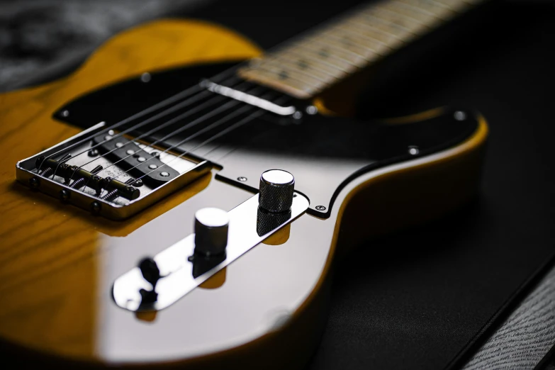 an electric guitar is lying down on a black surface