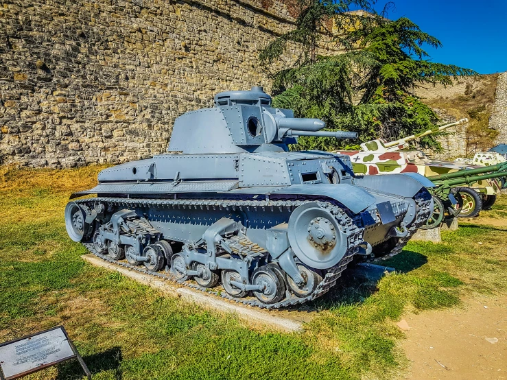 several old military tanks and signs are displayed