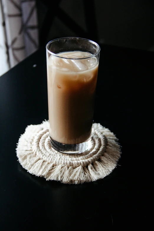 a drink is sitting on a mat on a table