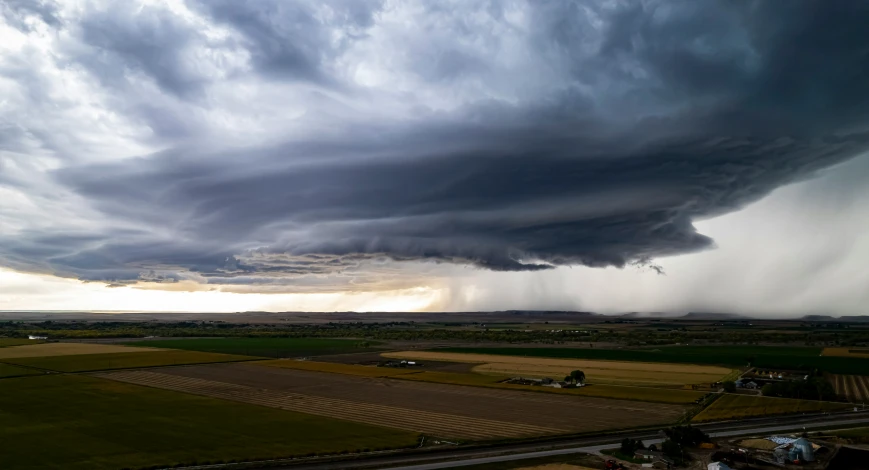 a large cloud looms over an open area of land