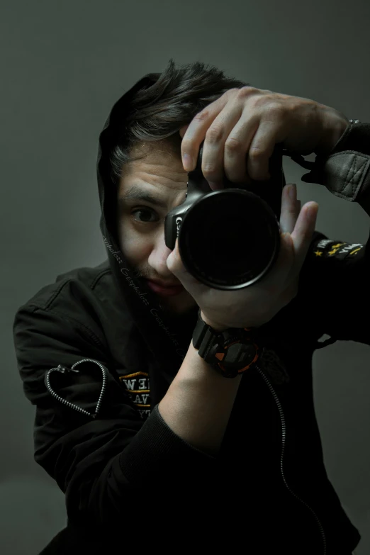 a woman holding a small black object up to her face