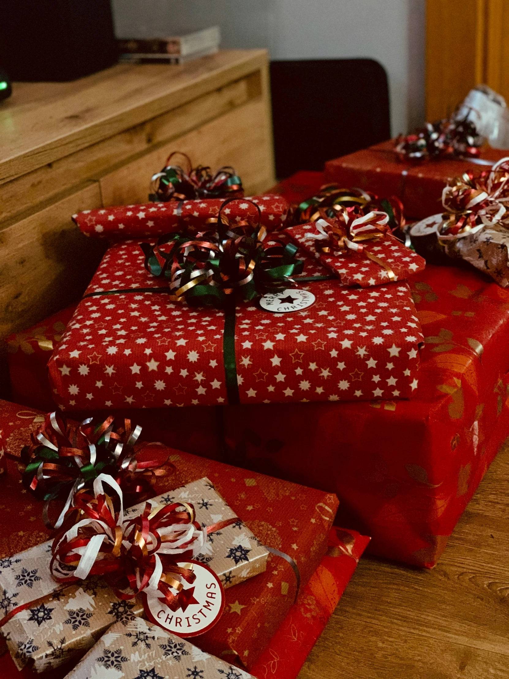 three red and white wrapped presents sitting on a wooden floor