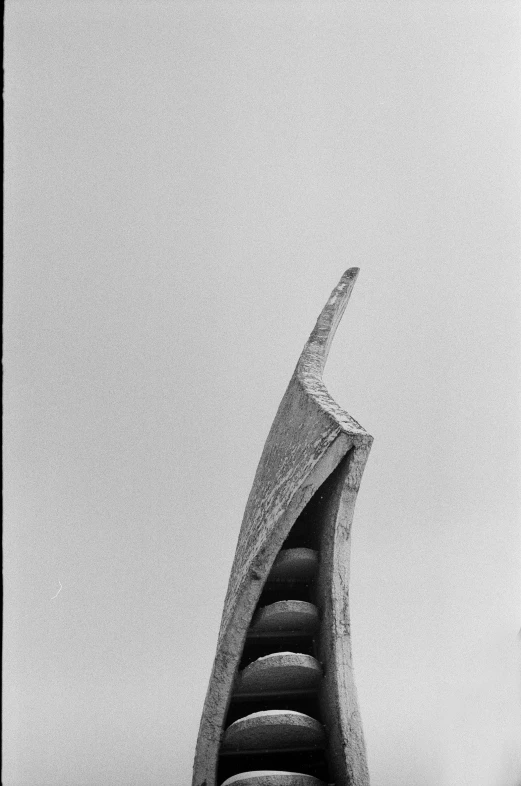 a modern sculpture looks up into the foggy sky