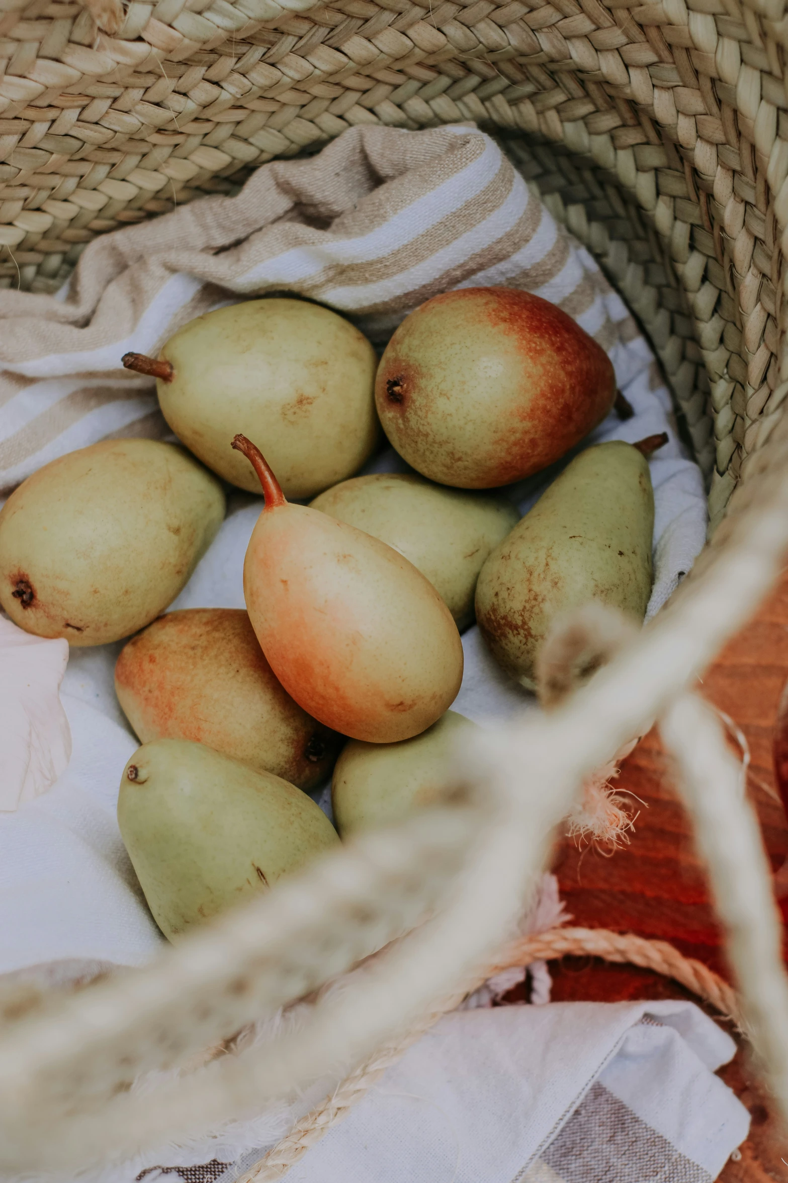 some pears that are in a basket on the floor