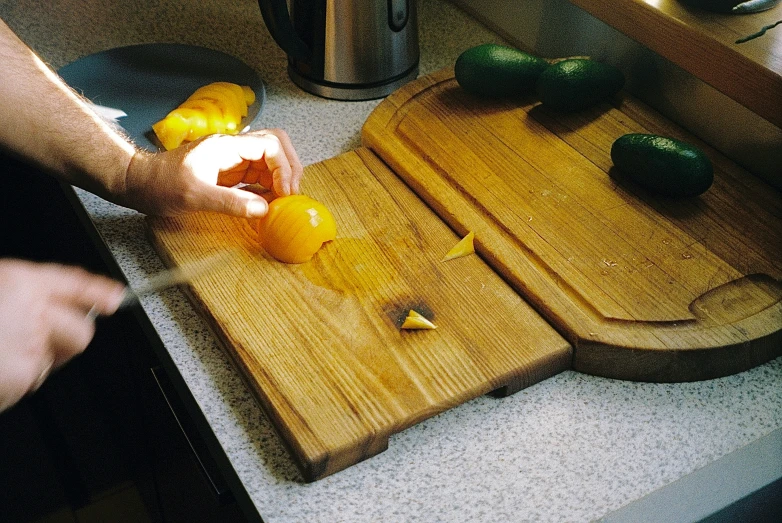an person is  up vegetables on a chopping board