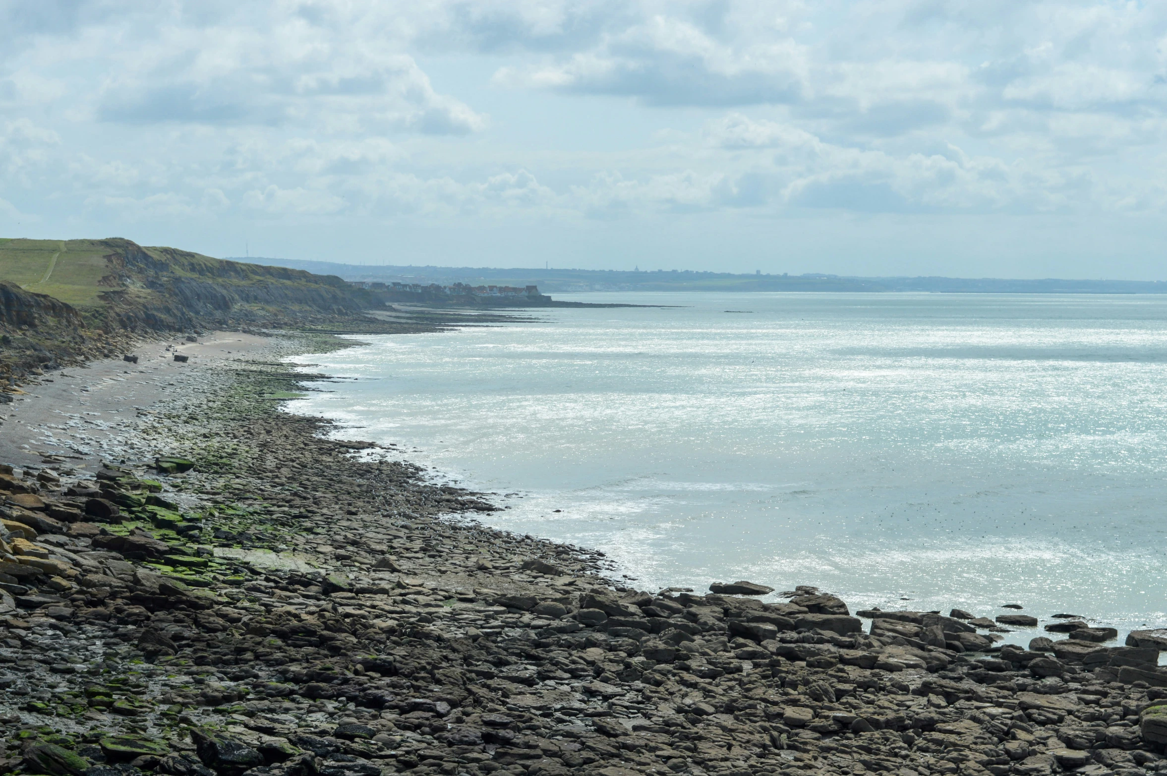 the ocean with a very rocky beach in front of it