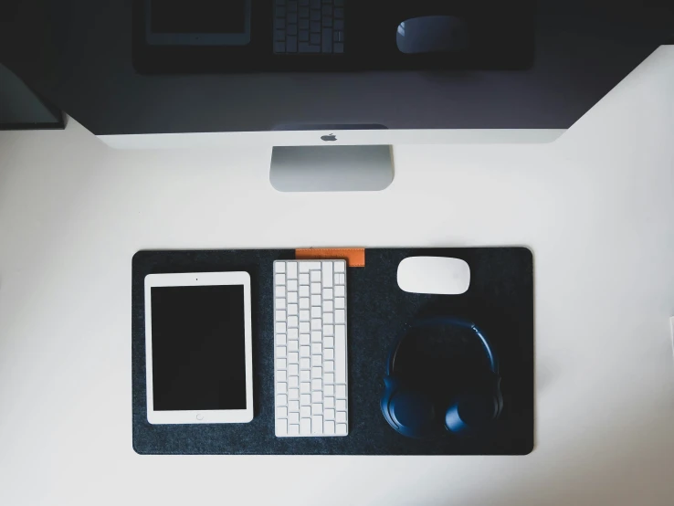 the desk has an office phone, mouse and keyboard on it