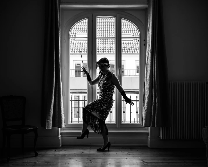 a woman with a hat and dress is posing in front of an open window