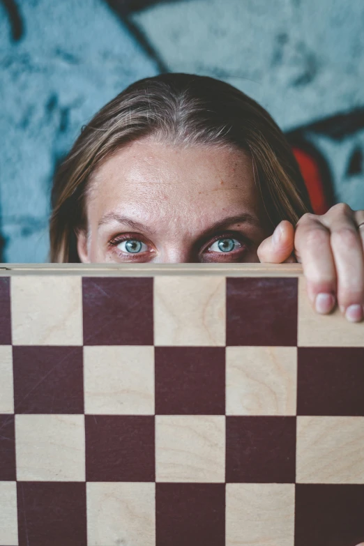 a woman has her eyes close to a checkerboard board