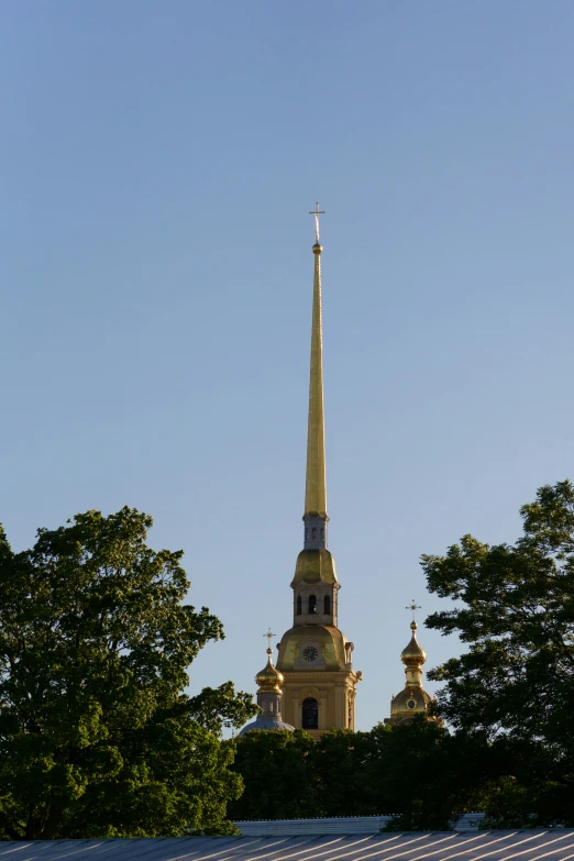 the steeple of a church with three spires and trees