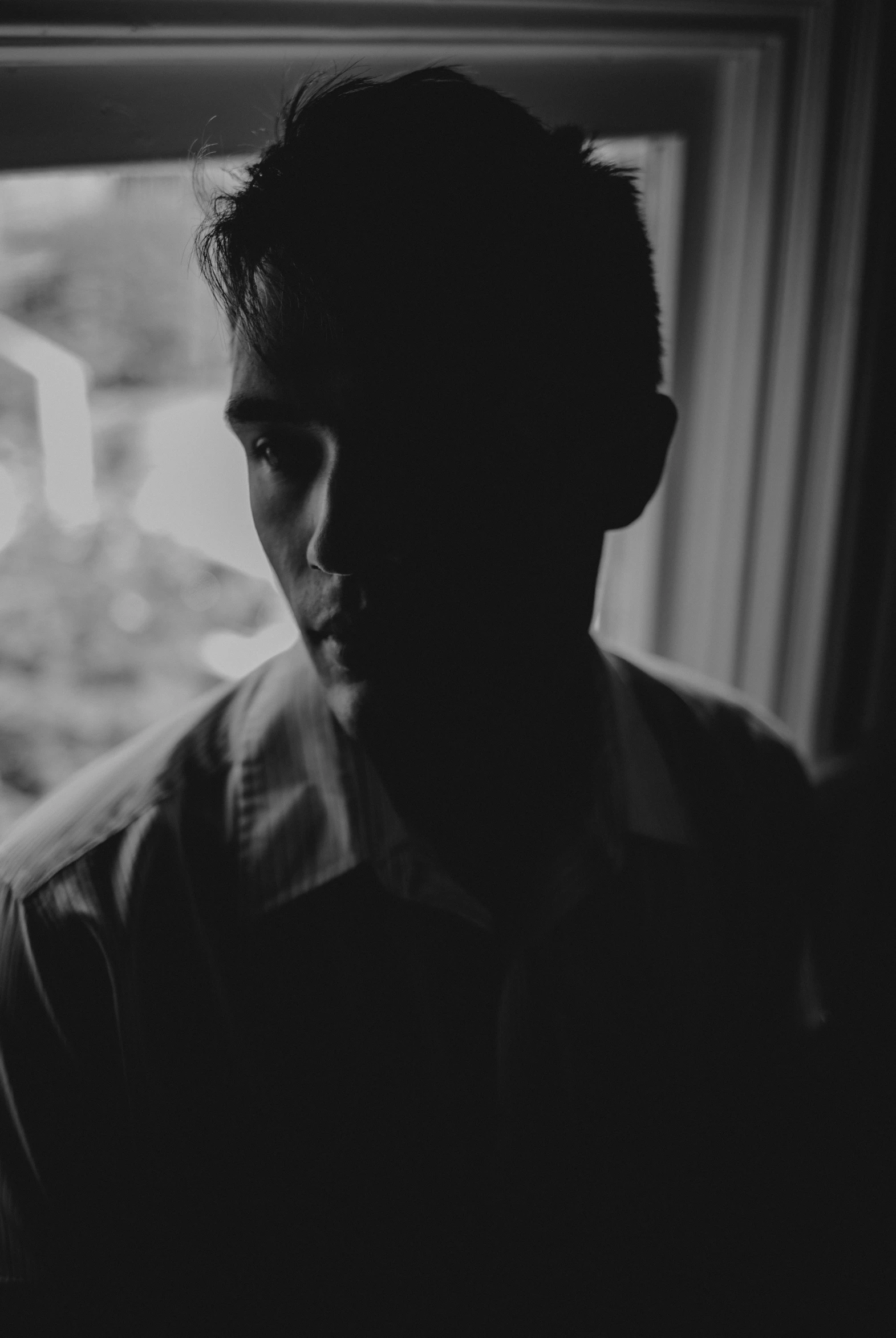 a man looking out of a window in the dark