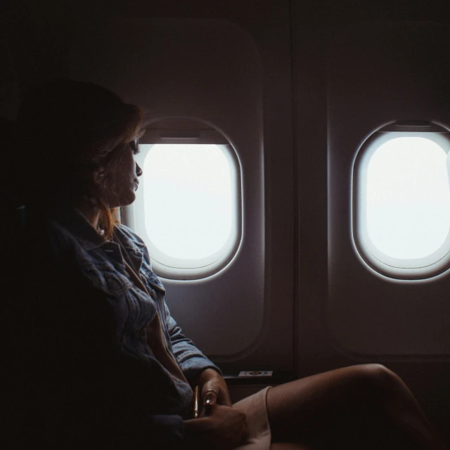 a person sitting on a seat in front of some windows