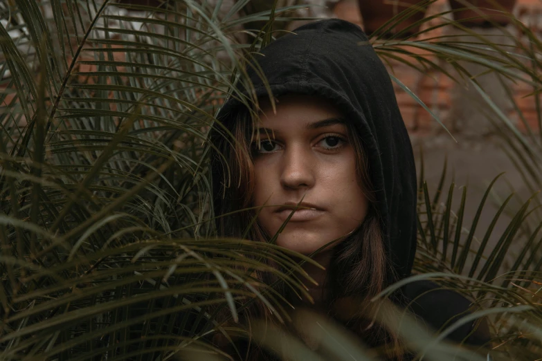 the woman is hiding her head behind trees