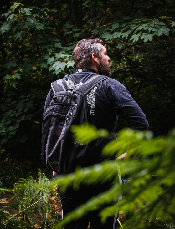 a man walking away from trees in the woods