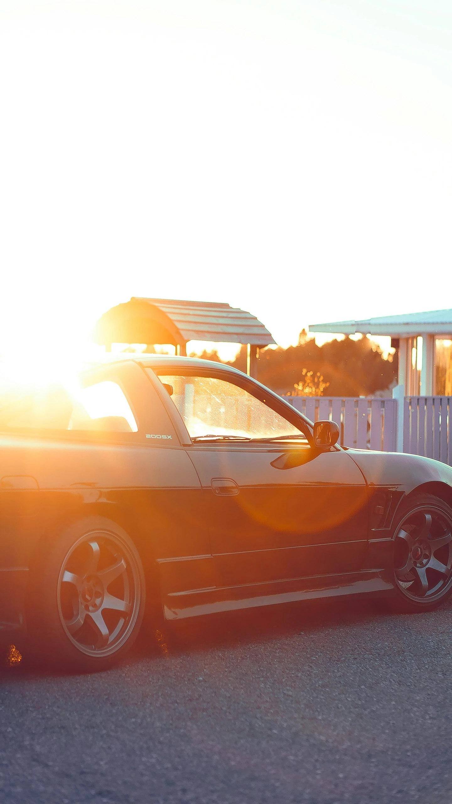 the car parked in the parking lot with the sun behind it